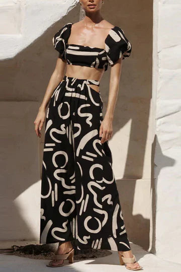 Ensemble assorti composé d'un top imprimé à épaules découvertes et d'une jupe longue avec découpes et poches, parfait pour un look d'été cool et à la mode.